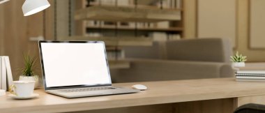 Modern bir oturma odasında ya da özel bir ofiste, masasında beyaz ekran modeli olan bir dizüstü bilgisayar. İş yeri konsepti. 3d görüntüleme, 3d illüstrasyon