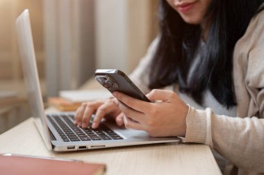 Asya 'lı bir kadının bilgisayarını bir kafede bilgisayarını kullanırken uzaktan kumandayla birden fazla iş yaparken görüntüsü. İnsanlar ve kablosuz teknoloji kavramları