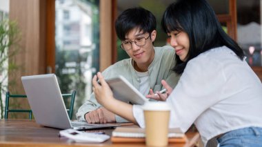 Olumlu, zeki bir Asyalı genç adam, bayan meslektaşının proje hakkındaki fikirlerini dinlerken, bir kafede birlikte çalışırlar..