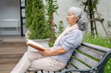 60 'lı yaşlarında sakin ve olgun bir Asyalı kadın elinde bir kitapla arka bahçesinde bir bankta oturuyor, okurken gözleri kapalı ve derin düşüncelere dalmış. Mutlu emeklilik hayatı, boş zaman