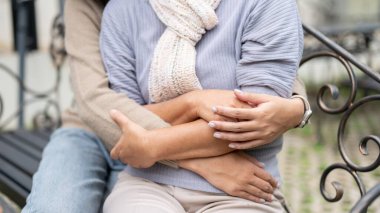 Bir kızın el ele tutuşup dışarıda bir bankta otururken annesine sarılışının görüntüsü. Sarılma, sarılma, aşk, bağlanma, birliktelik, güven, cesaret