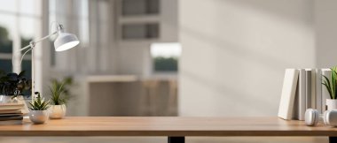 Modern beyaz bir odadaki ahşap bir çalışma masasında ürünleri sergilemek için kullanılan bir kopya alanının yakın plan görüntüsü. Masada kitaplar, dekor bitkileri ve bir masa lambası yer alıyor. 3d görüntüleme, 3d illüstrasyon