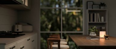 Masa lambası, mutfak gereçleri ve dekorla aydınlatılmış pencerenin kenarındaki tabureli ahşap bir yemek masası olan rahat bir mutfak sahnesinin yan görüntüsü. 3d görüntüleme, 3d illüstrasyon