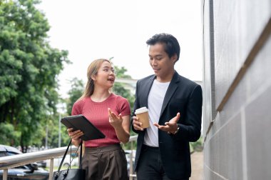 Güzel, pozitif Asyalı bir bayan asyalı asistan ya da sekreter dışarıda bina boyunca yürürken iş ve fikirlerini patronuyla paylaşıyor..