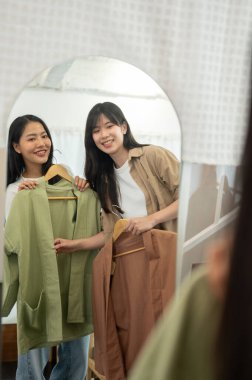 İki güzel ve neşeli Asyalı genç bayan arkadaş bir mağazada alışveriş yapmaktan zevk alıyorlar. Kıyafetlerini deniyorlar ve aynada kendilerine hayranlık duyuyorlar. Arkadaşlık, yaşam tarzları, rahatlık