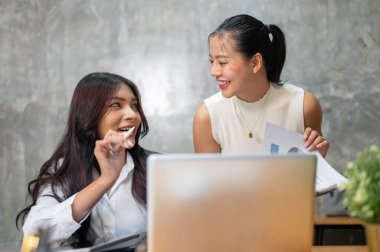 Harika bir Asyalı iş kadını, iş arkadaşıyla iş hakkında konuşuyor, beyin fırtınası yapıyor ve fikirlerini paylaşıyor. İş insanları kavramı