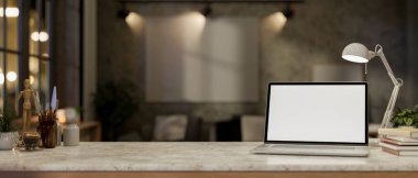 Mermer bir masanın üzerinde beyaz ekran maketi olan bir dizüstü bilgisayarın yakın çekimi, bir masa lambasıyla aydınlatılmış, gece oturma odasının bulanık arka planına ayarlanmış. 3d görüntüleme, 3d illüstrasyon