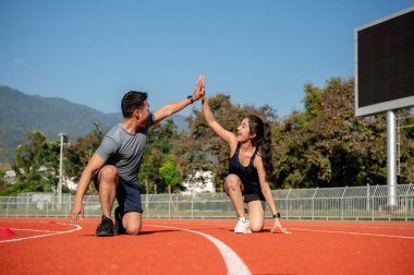 Güneşli bir günde bir stadyumda antrenman yapmaya hazırlanan iki Asyalı koşucu beşlik çakıyor. İnsanlar, dostluk ve spor kavramları