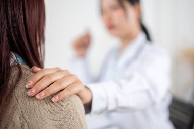 Hastanedeki bir muayene odasında bir hastanın omzuna nazikçe dokunarak onu rahatlatan ve rahatlatan bir doktorun yakın plan görüntüsü. sağlık hizmeti kavramı