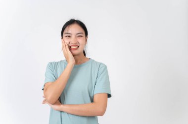 Hasta, rahatsız, genç Asyalı bir kadın yanağına dokunuyor, diş ağrısı çekiyor, sağlık sorunu yüzünden mutsuz. izole edilmiş beyaz stüdyo