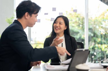 İki iş adamı toplantı odasında buluşuyor, güzel güzel sohbet ediyorlar. Güzel, pozitif Asyalı bir iş kadını erkek arkadaşıyla bir projeyi tartışıyor..