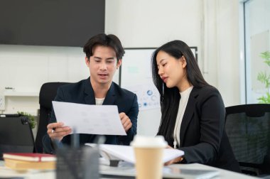 İki zeki ve profesyonel Asyalı iş adamı bir toplantı odasında bir takım olarak çalışırken finansal bir proje planlayıp tartışıyorlar..