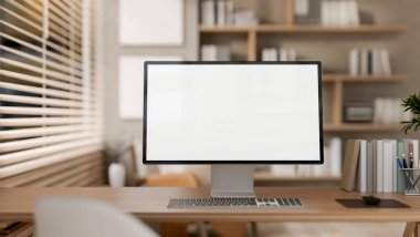 Samimi bir İskandinavya odasındaki pencerenin yanındaki ahşap bir masaya yerleştirilmiş beyaz ekran maketi olan bir bilgisayarın yakın çekim görüntüsü. ev ofisi, ofis, iş yeri, 3D resim, 3D resim