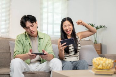 Sevimli, neşeli Asyalı bir çift akıllı telefonlarıyla yarışmaktan ve evde birlikte eğlenmekten zevk alır. Biri kazanır, diğeri ise kaybeden gibi davranır..