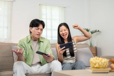 Sevimli, neşeli Asyalı bir çift akıllı telefonlarıyla yarışmaktan ve evde birlikte eğlenmekten zevk alır. Biri kazanır, diğeri ise kaybeden gibi davranır..