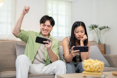 Sevimli, neşeli Asyalı bir çift akıllı telefonlarıyla yarışmaktan ve evde birlikte eğlenmekten zevk alır. Biri kazanır, diğeri ise kaybeden gibi davranır..