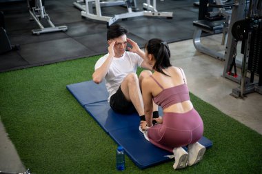 Odaklanmış ve kararlı bir Asyalı, kız arkadaşı ya da spor salonunda antrenörlük yaparken mekik çekiyor..