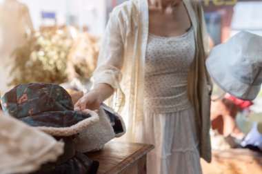 Mutlu bir Asyalı kadının yakın plan çekimi şapkacıda ürünleri dikkatlice seçmesi, alışveriş çılgınlığının keyfini çıkarması. moda, yaşam tarzı, alışveriş, tatil