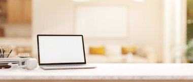 Boş ekran maketi ve beyaz bir masanın üzerinde modern, parlak bir oturma odasının bulanık arka planına sahip bir laptop. 3d görüntüleme, 3d illüstrasyon