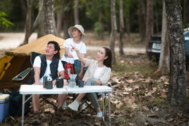 Üç kişilik bir aile, bir oğlu olan anne ve baba, ormanda kamp yapmaya gider. Annem işaret ediyor. Aile gezisi, açık hava aktivitesi.