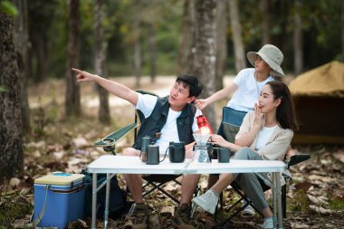 Üç kişilik bir aile, bir oğlu olan anne ve baba, ormanda kamp yapmaya gidiyorlar. Babası işaret ediyor. Aile gezisi, açık hava aktivitesi.