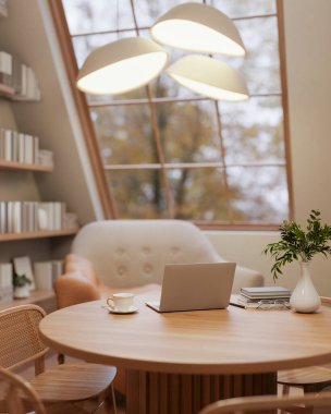 Şık lambanın altındaki tahta masa ve koltuklar yeryüzü ses odasındaki çatı penceresinin yanında. Rahat çalışma odası ya da kütüphane. 3 Boyutlu Hazırlama, 3 Boyutlu Resim.