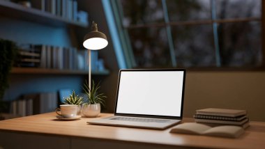Karanlık odadaki çatı penceresinin altına dekorasyon malzemesi yerleştirilmiş ahşap masadaki beyaz ekran laptop. Çalışma odası ya da gece oturma odası. 3 Boyutlu Hazırlama, 3 Boyutlu Resim.