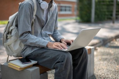 Gri gömlekli bir adamın dizüstü bilgisayarında yazarken ya da sohbet ederken, kitapların yanında otururken ve kaldırım kenarındaki bankta telefon çalarken. Boş zaman geçirmek, çalışmak ya da dışarıda çalışmak..