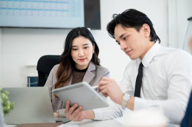 Erkek ofis çalışanı tablet ekranına bir stil gösteriyor. Kadın iş arkadaşı, iş adamı ve iş kadınına iş verilerini gösteriyor..