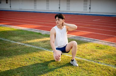 Beyaz atlet Asyalı adam çim tarlasında boynunun arkasında bir eliyle çömeliyor. Acı ya da Gerilim. Açık hava egzersizi ya da eğitim. Spor ve sağlık.