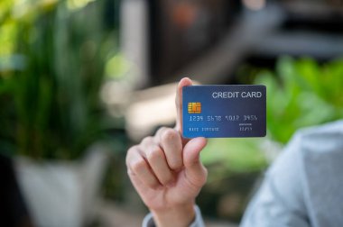 Kafedeki ya da kahve dükkanındaki ahşap masada otururken el ele tutuşmak ya da mavi bir kredi kartı göstermek. Banka ilanı, fatura ödeme..