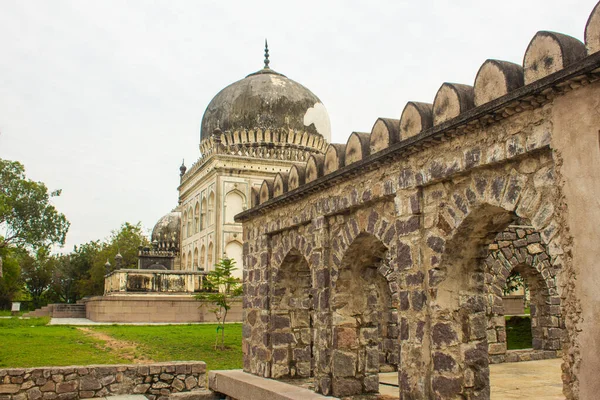 stock image Corridor between tomb structures and the landscaped garden at Qutb Shahi Archaeological Park, Hyderabad, India