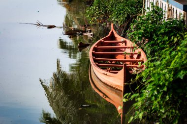 Kerala 'nın Hindistan eyaletindeki Kochi durgun sularında konuşlanmış bir kano. Conoe, yerel halk için dolaşmanın geleneksel yoludur..