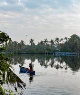 Kochi, Keral, Hindistan - 14 Mayıs 2024: Hindistan 'ın Kerala eyaletindeki Kochi durgun sularında bir kanoyla hareket eden bir bölge.