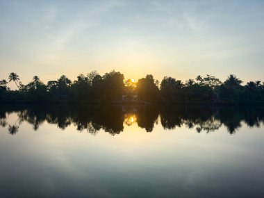 Hindistan 'ın Kerala eyaletindeki Kochi durgun sularının güzel simetrik yansıması. Kochi (ayrıca Cochin olarak da bilinir) birçok durgun sulara sahip bir kıyı kentidir..