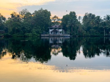 Hindistan 'ın Kerala eyaletindeki Kochi durgun sularının güzel simetrik yansıması. Kochi (ayrıca Cochin olarak da bilinir) birçok durgun sulara sahip bir kıyı kentidir..