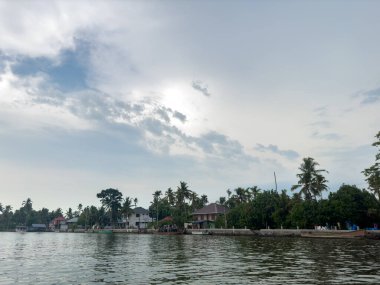 Alleppey, Kerala, Hindistan - 15 Mayıs 2024: Hindistan 'ın Kerala eyaletindeki Alappuzha durgun suları boyunca Houseboat gezisinden habitat manzarası.