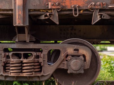 Paslı tren vagonlarının tekerlekleri. Malların uzun mesafelerde taşınması, ağır sanayi konsepti. Seçici odak ile yakın plan