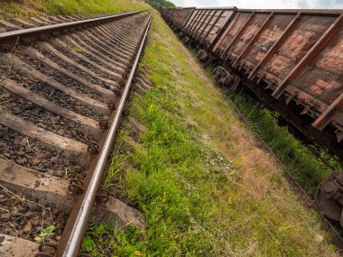 Eski demiryolu rayları ve pusucuları yakın plan. Derecelendirme bölümü, arkada yük vagonları. Ürünlerin uzun mesafelerde taşınması, ağır sanayi kavramı