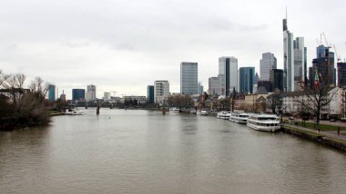 View downstream of the river Main, with skyline of modern skyscrapers of the right bank of the river, Frankfurt, Germany - January 22, 2023