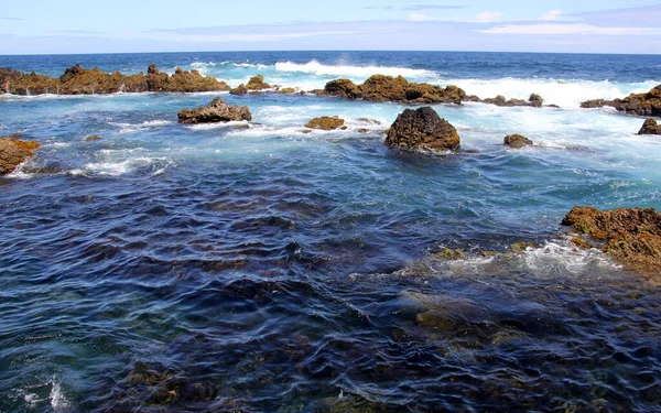 2022年7月27日葡萄牙亚速尔Terceira北部海岸Biscoitos沿岸海浪中火山熔岩形成的岩石 免版税图库照片