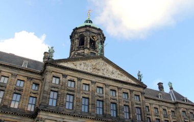 Amsterdam Kraliyet Sarayı, Baraj Meydanı 'na bakan ön taraf, kısmi manzara, kubbeli saat kulesi ve heykeller, Amsterdam, Hollanda - 1 Ocak 2013