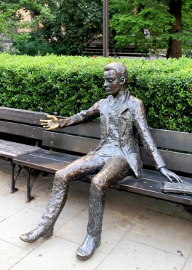 Student, bronze sculpture, in front of the Old University Library building, aka Collegium Novum, on the main campus of the University of Warsaw, Poland - July 4, 2012