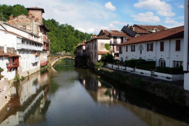 Kıyılardaki evler ve Nive nehri üzerindeki eski köprü, Saint-Jean-Pied-de-Port, geleneksel Aşağı Navarrey Bask bölgesinin eski başkenti, Fransa - 13 Mayıs 2017