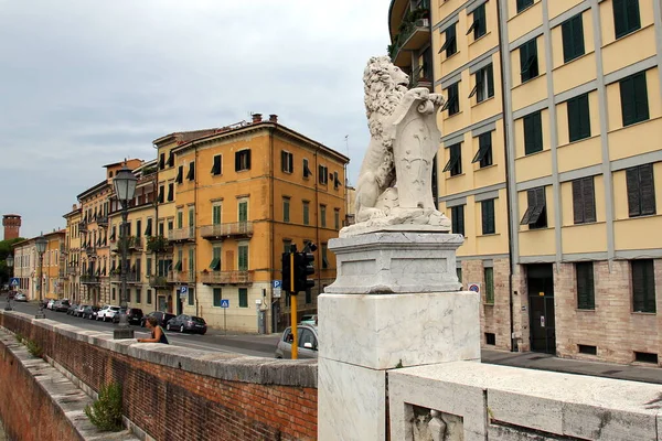 stock image Lion holding a cartouche with heraldic cross, stone carved sculpture at the embankment of Arno river, Pisa, Italy - August 1, 2015