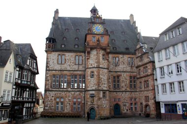 16. yüzyıl tarihsel belediye binası, Rönesans astronomik saati ile, Yukarı Şehir, Oberstadtmarkt Pazar Meydanı 'nda, günbatımı gölgelerinde, Marburg, Almanya - 29 Ocak 2023