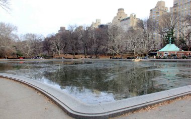 Beşinci Cadde ufuk çizgisi, Central Park 'tan manzaralı Konservatuar Suyu üzerinde, karsız bir kış öğleden sonrasında, New York, New York, New York, ABD - 23 Aralık 2023