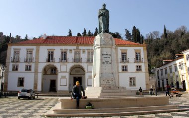 Şehrin kurucusu Gualdim Pais 'in anıtı, Cumhuriyet Meydanı' nda, arkadaki belediye binası, Tomar, Portekiz - 6 Şubat 2024