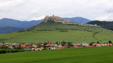 Slovakya 'nın doğusunda, 24 Mayıs 2025' te Orta Çağ 'dan kalma Spis Kalesi' nin kalıntıları, yemyeşil, dağ zeminli tarlalarla çevrili.