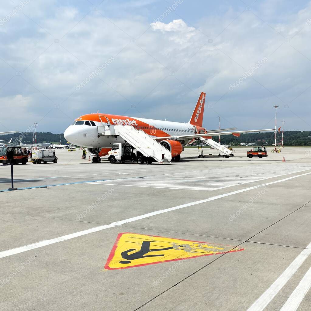 Airbus A320-214 airplane in EasyJet orange and white livery parked on the tarmac at Krakow International Airport, Poland - June 6, 2025